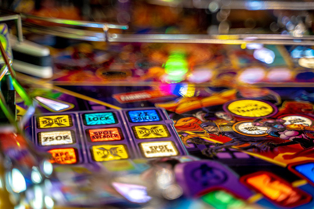 Close-up of a pinball machine with colorful buttons and lights.