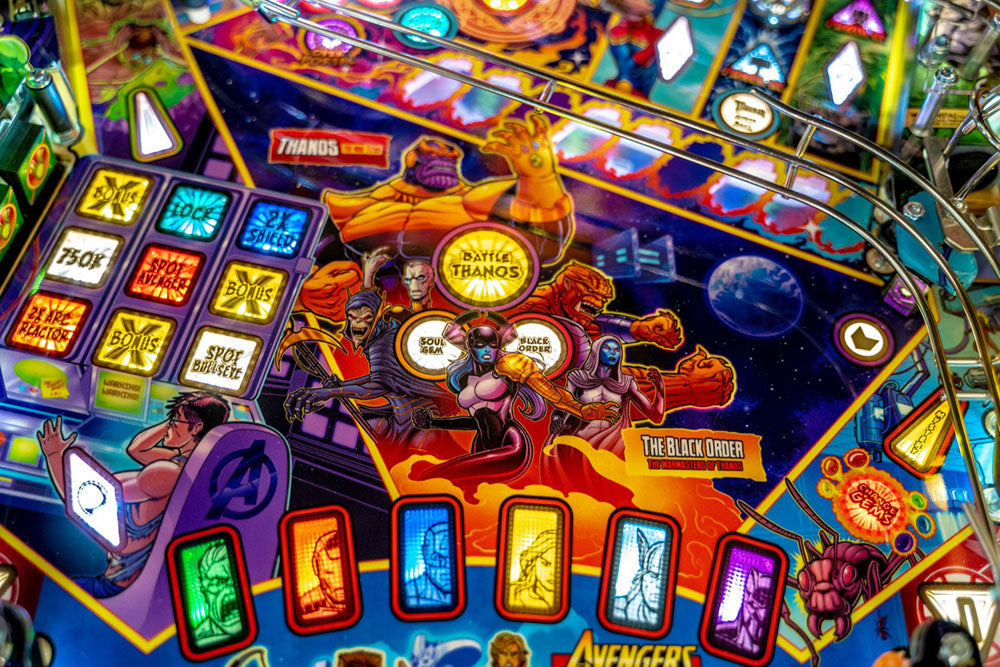 Close-up of a colorful pinball machine with various symbols and lights.