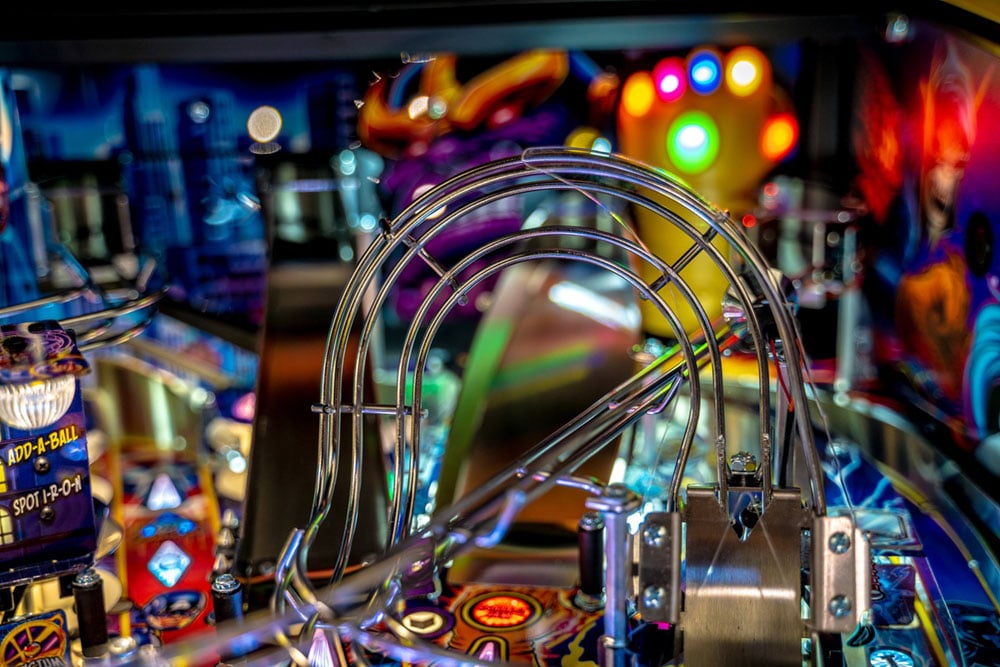 Close-up of a pinball machine with colorful lights and details.