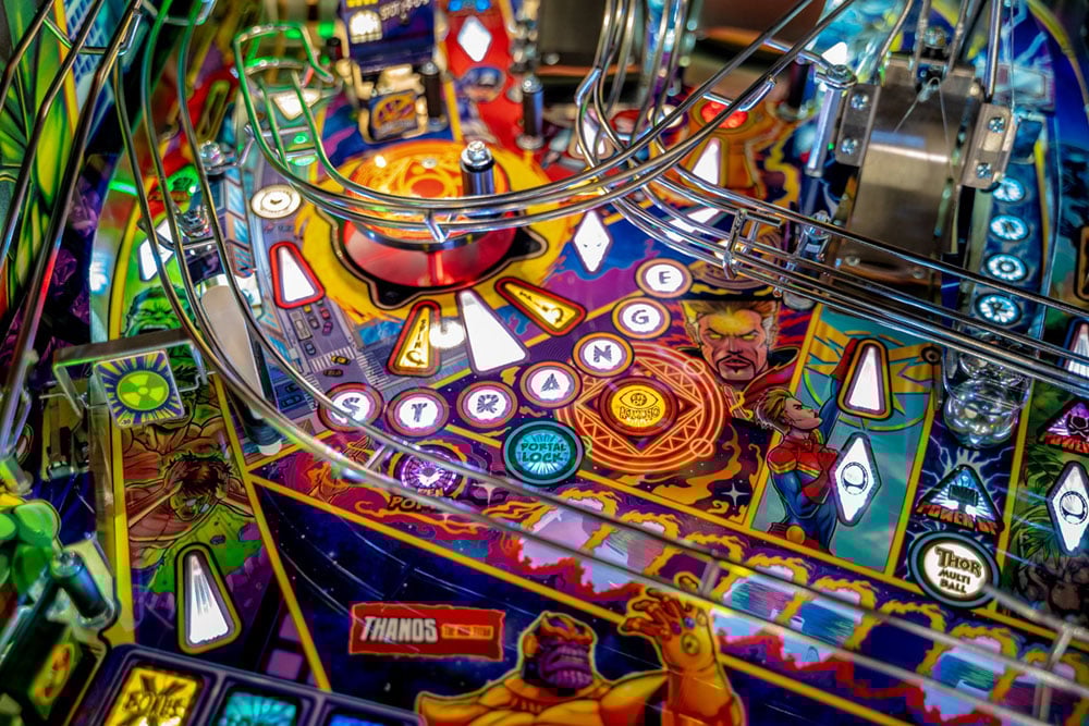 Close-up of a colorful pinball machine with various symbols and designs.