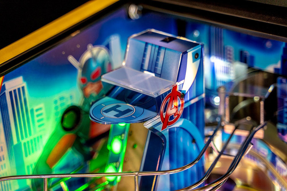 Close-up of a pinball machine with an 'Avengers' logo and colorful background