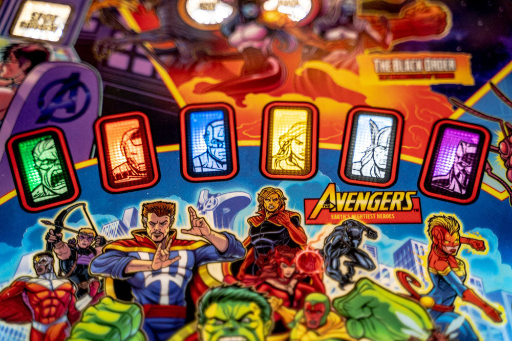Pinball machine with Avengers characters and colorful marquee lights.