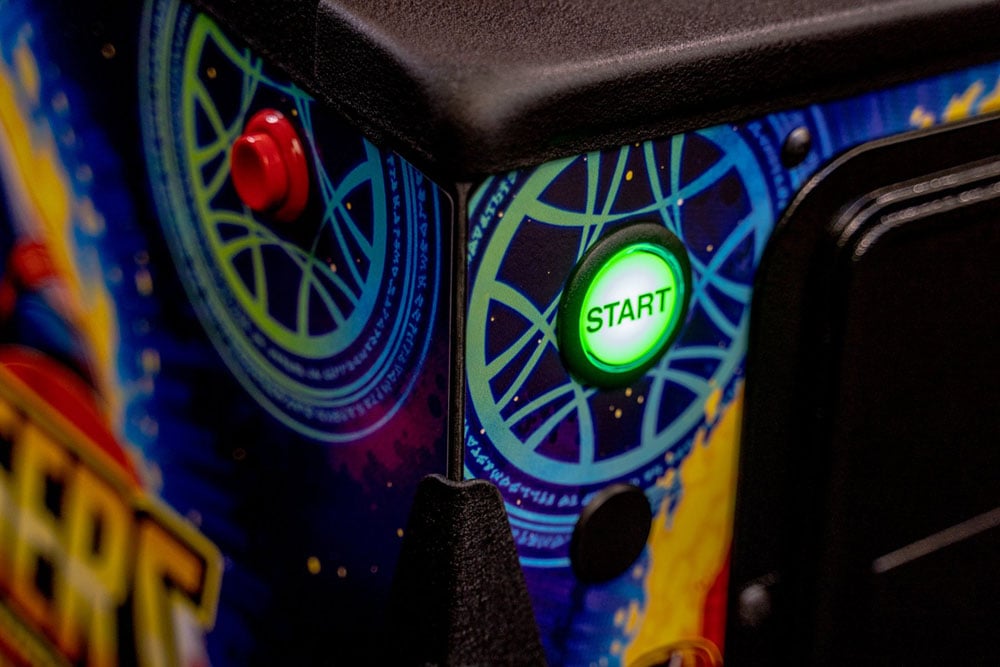 Close-up of a colorful arcade machine with a 'Start' button and joystick.