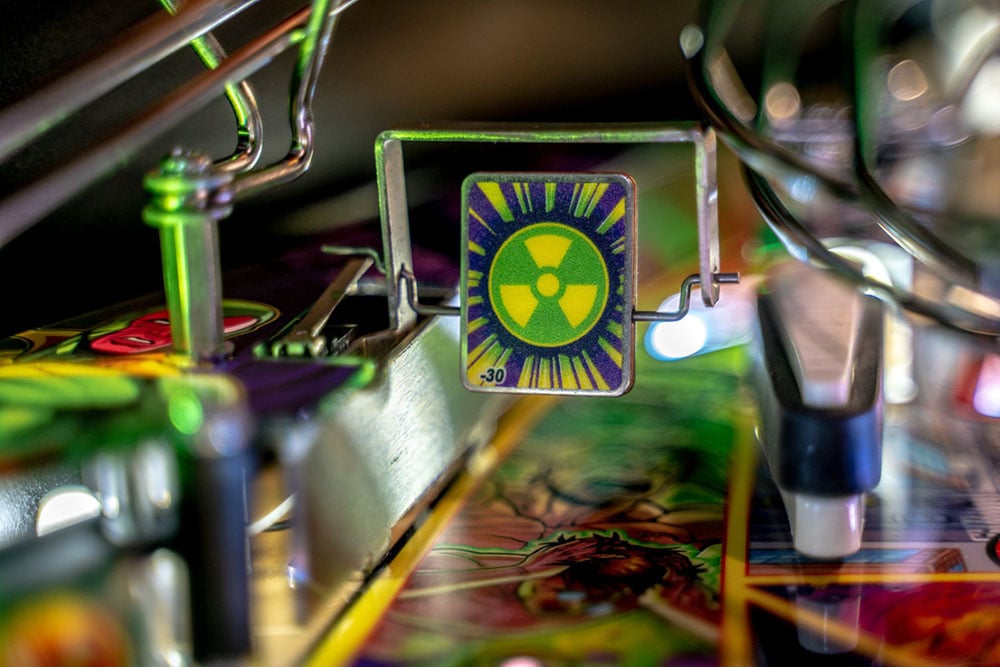 Close-up of a pinball machine with a radioactive symbol on a colorful background