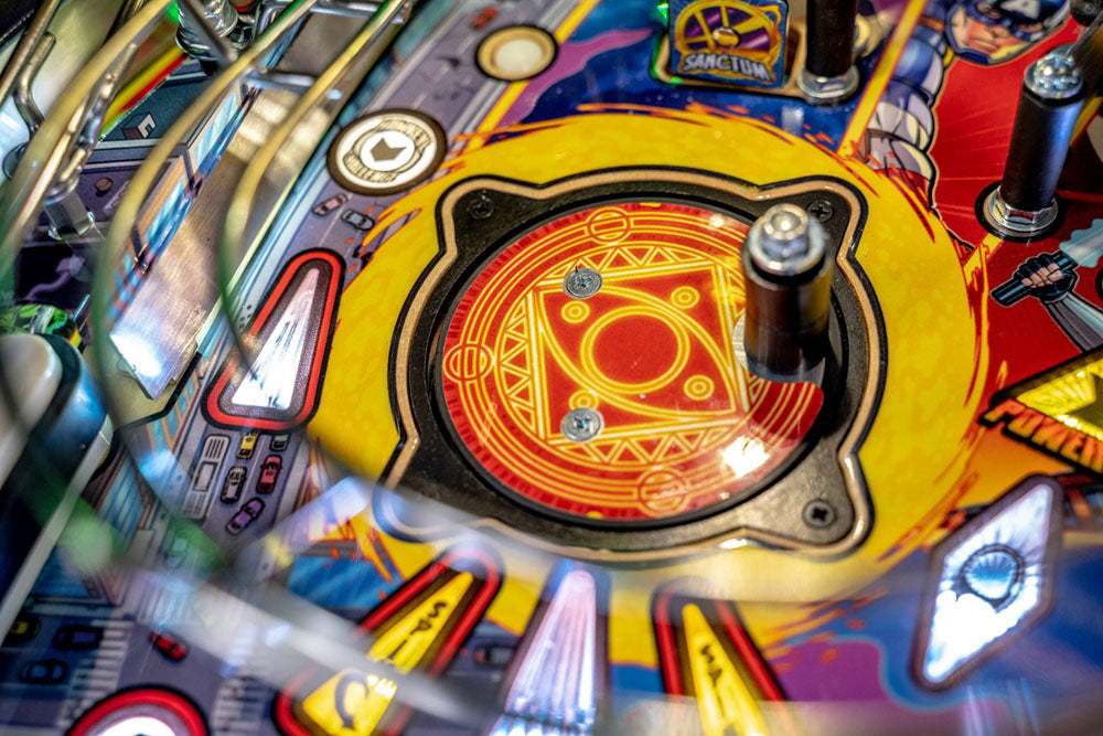Close-up of a colorful pinball machine with a bright yellow and red playfield.