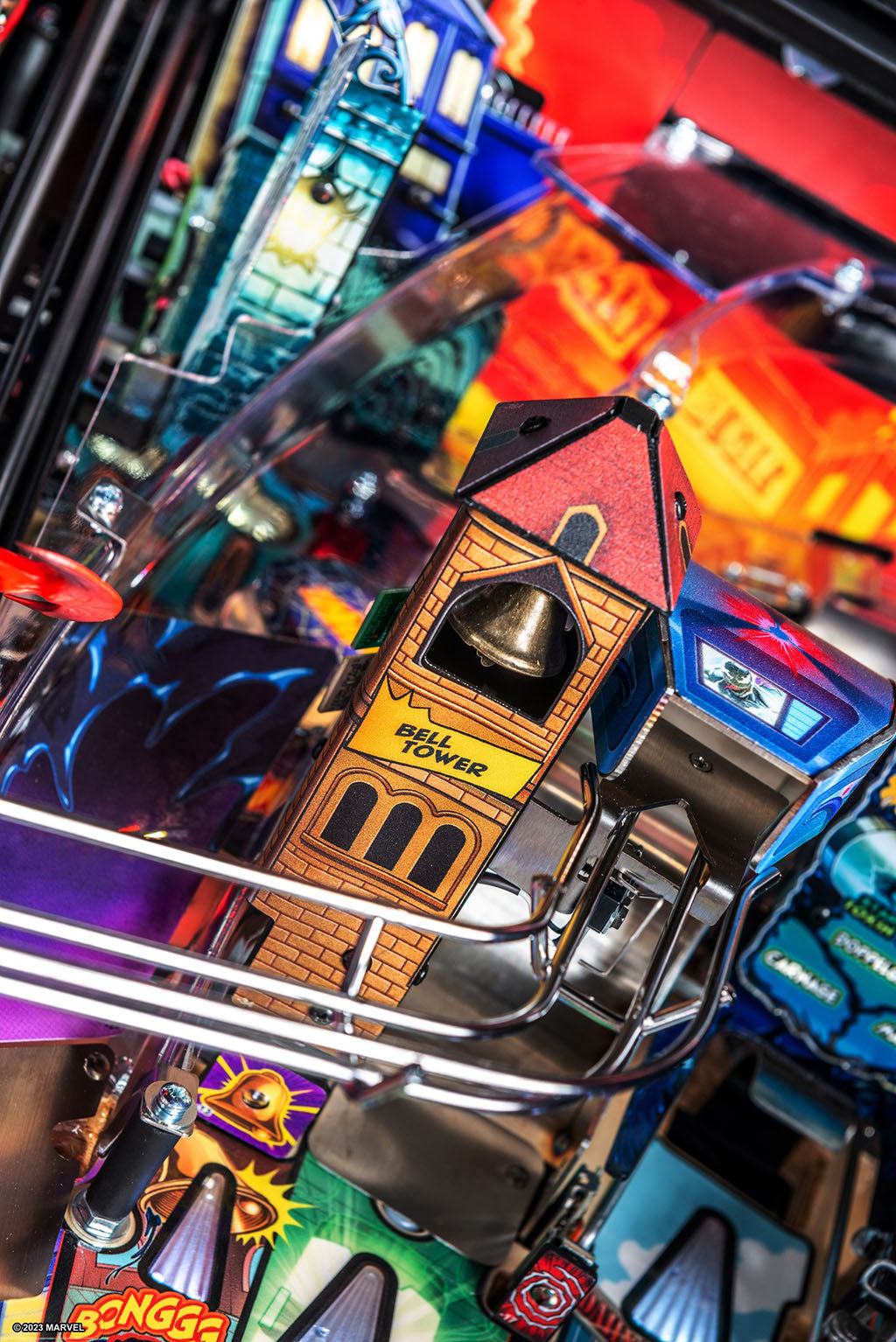 Close-up of a pinball machine with a detailed bell tower component.