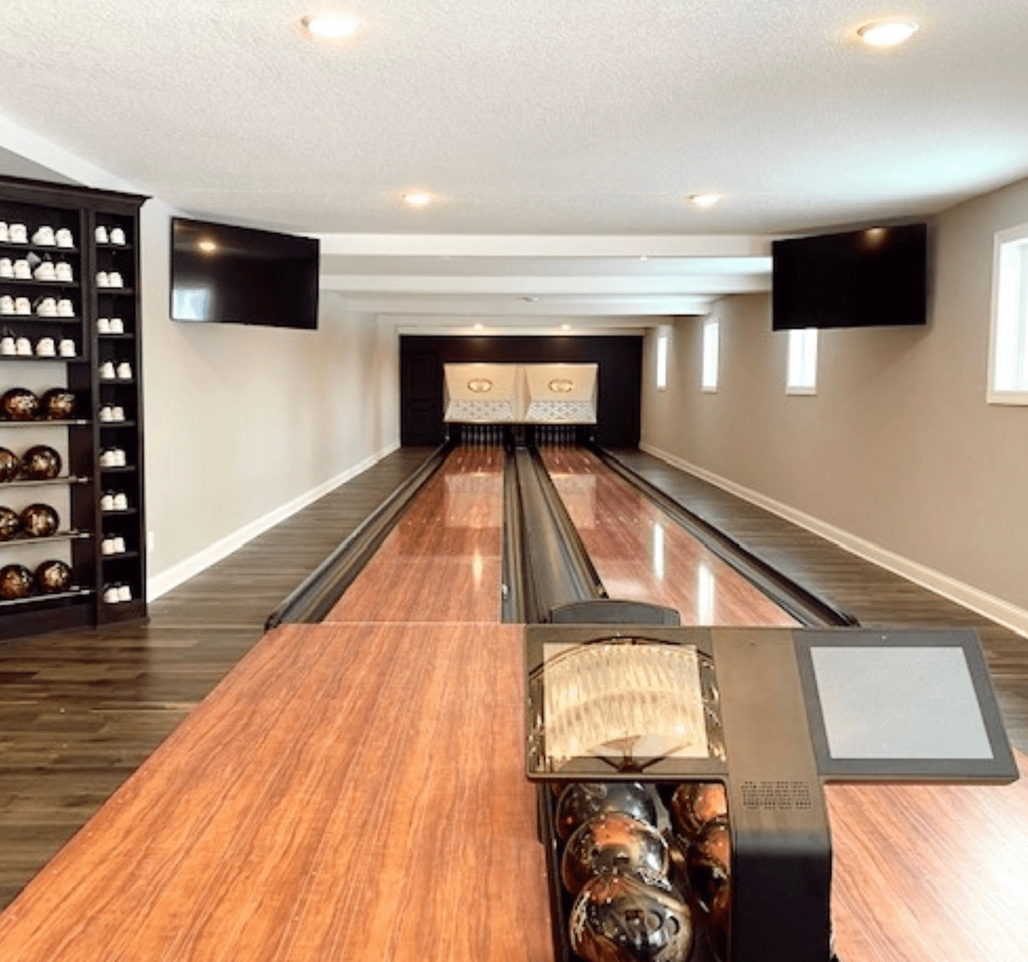 Home Tenpin Bowling Alley. Very modern interior. While walls, clean lines. Windows can be seen to the right.