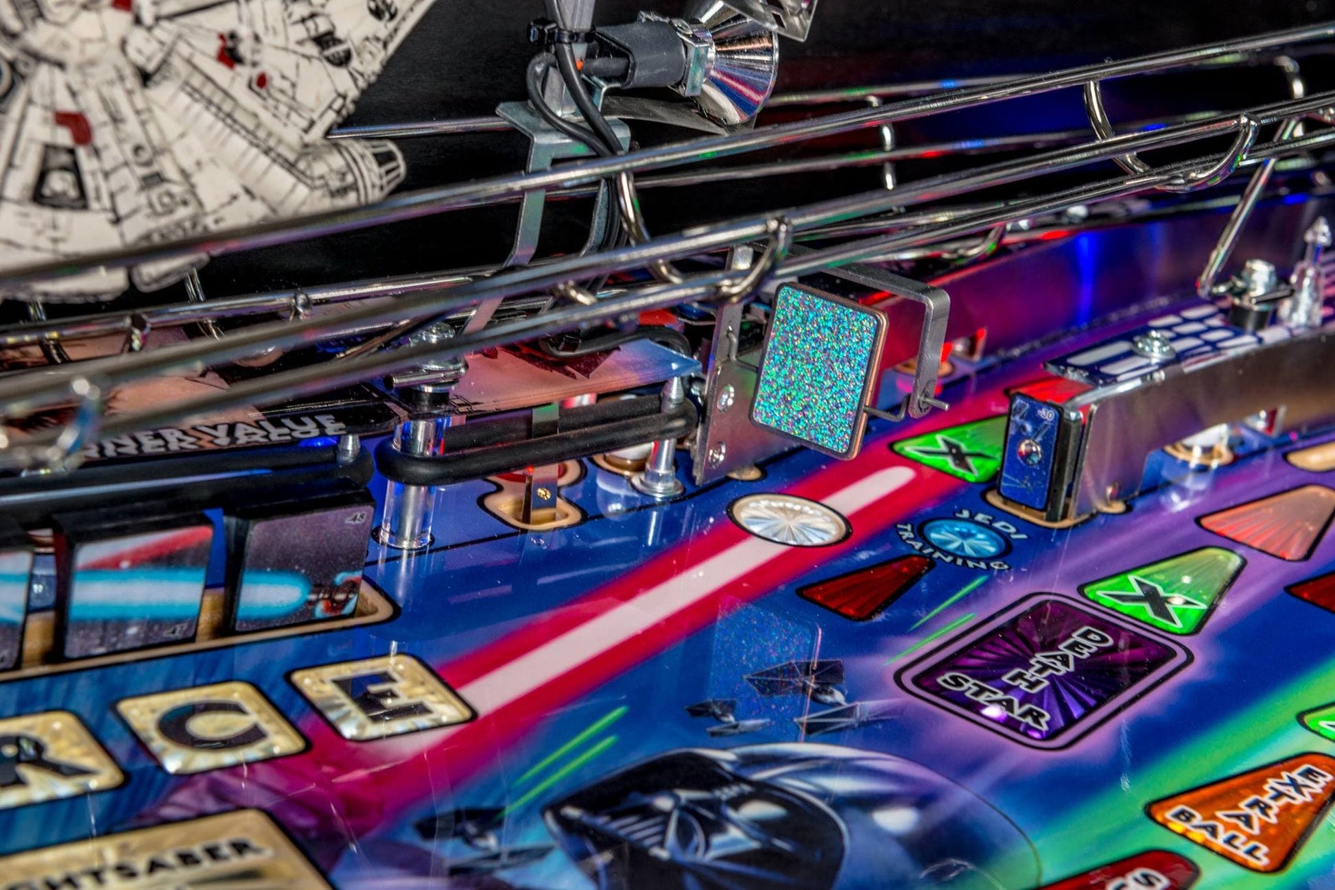Close-up of a colorful pinball machine with various symbols and text.