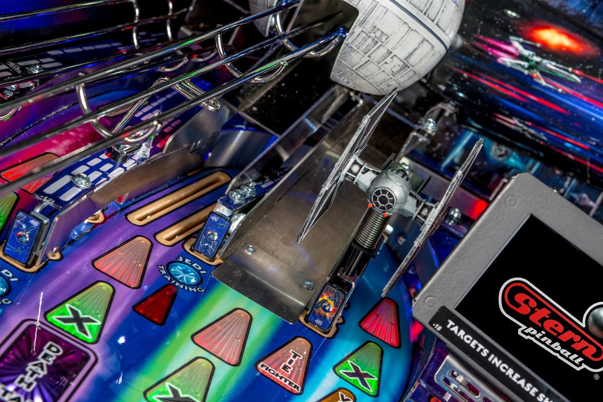 Close-up of a pinball machine with a detailed playfield and Stern logo.
