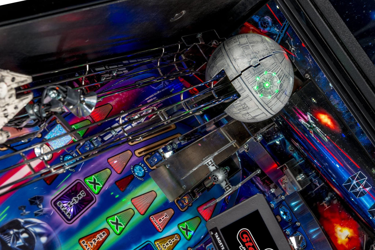 Close-up of a pinball machine with a Death Star figure and colorful playfield