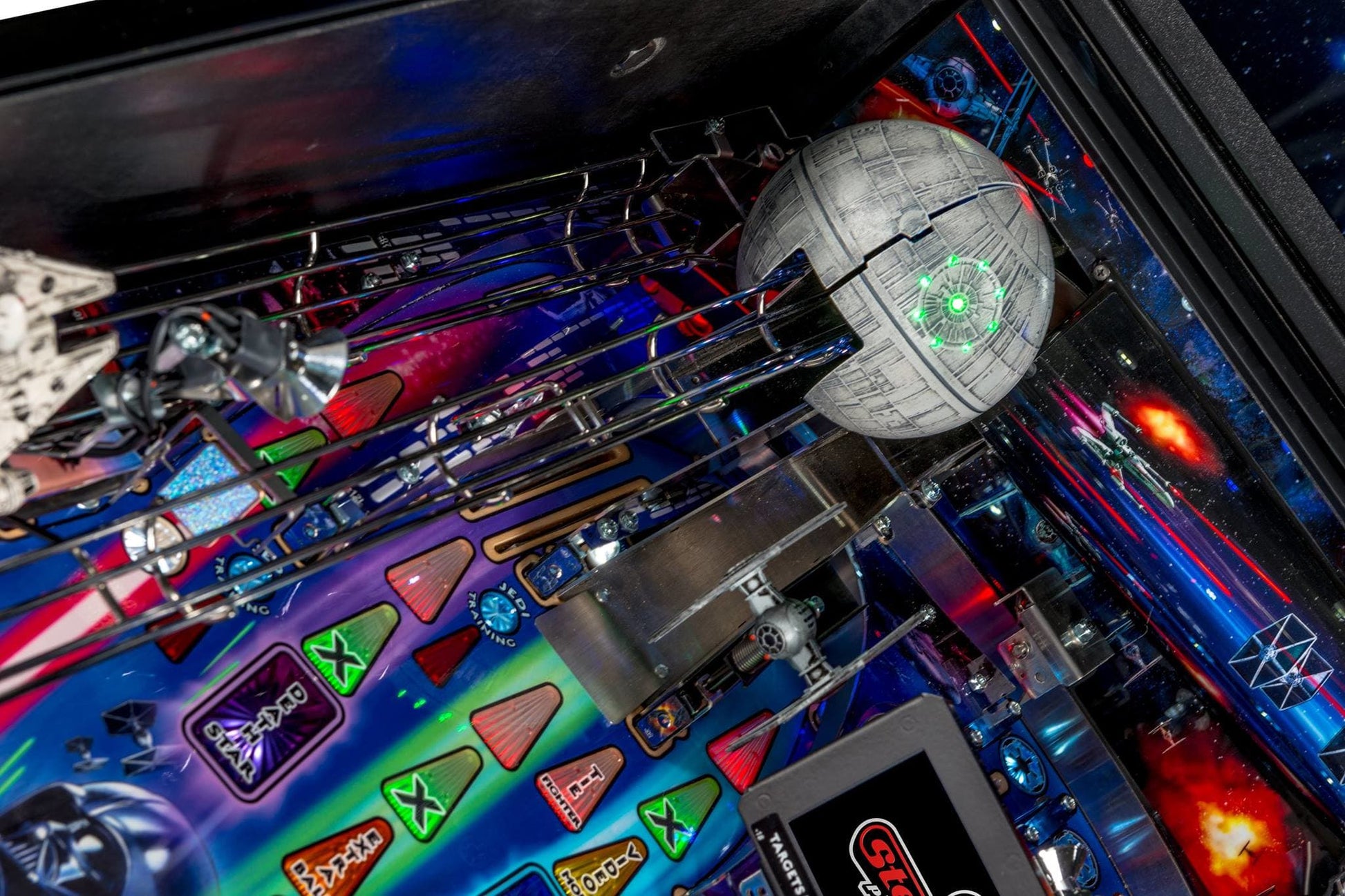 Close-up of a pinball machine with a Death Star figure and colorful playfield
