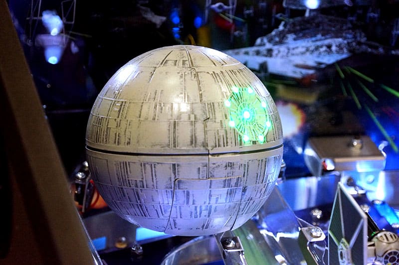 Model of the Death Star with glowing lights on a reflective surface