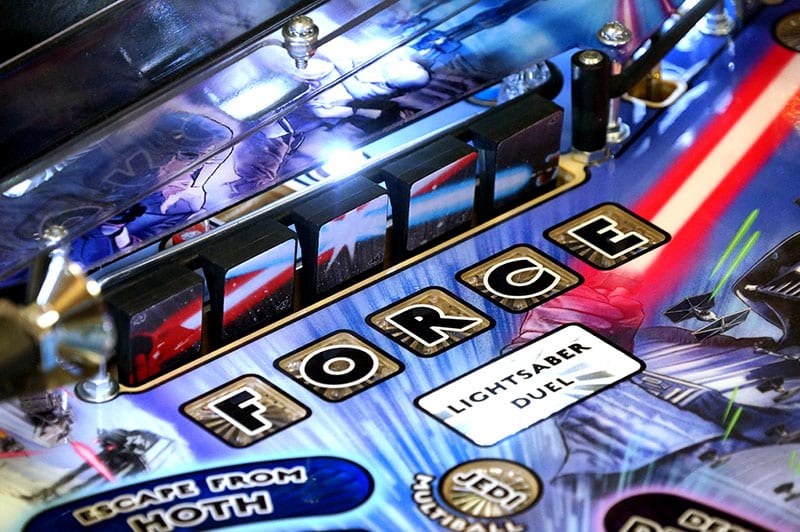 Close-up of a pinball machine with 'Star Wars' theme, featuring text and graphics.