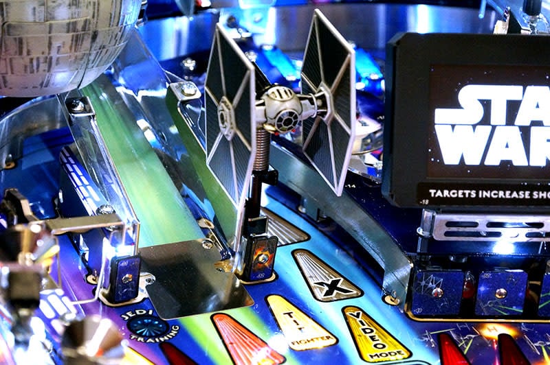 Pinball machine with Star Wars theme featuring a TIE fighter and Darth Vader figure.