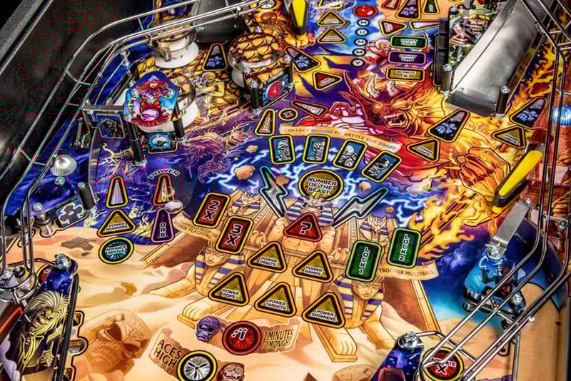 Close-up of a colorful pinball machine with various symbols and lights.
