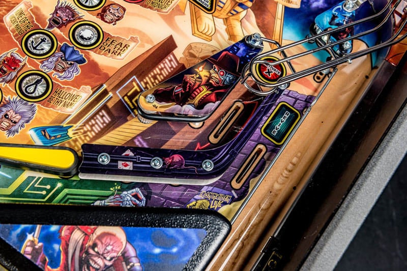 Close-up of a pinball machine with colorful artwork and mechanical components.