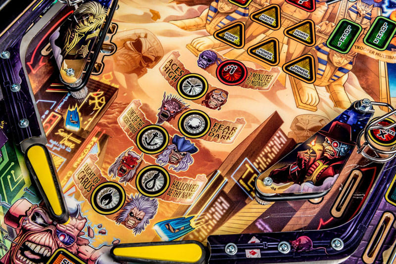 Close-up of a colorful pinball machine with various symbols and designs.