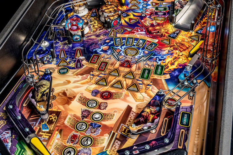 Close-up of a colorful pinball machine with various components and lights.