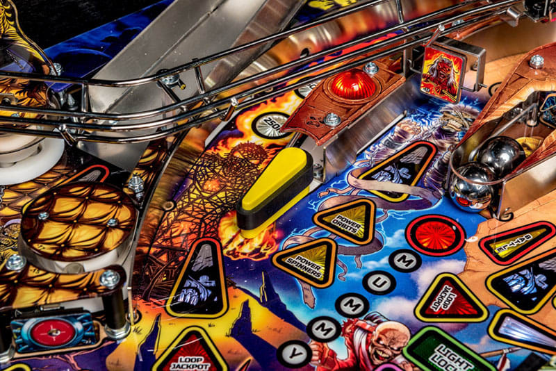 Close-up of a colorful pinball machine with various buttons and symbols.