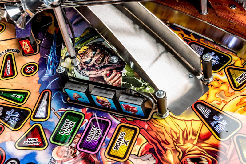 Close-up of a pinball machine with colorful playfield and various buttons.