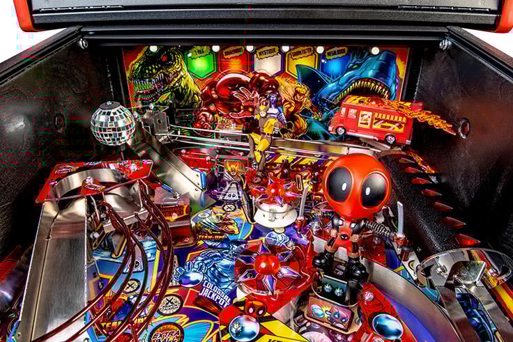 Close-up of a colorful pinball machine with various characters and elements.