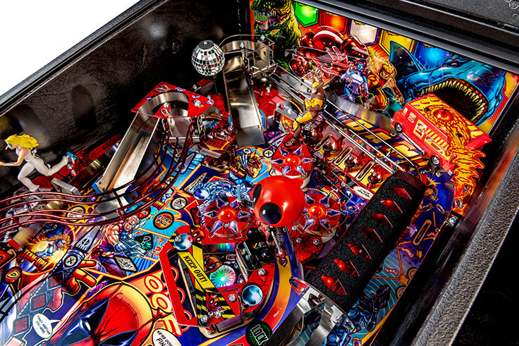 Close-up of a colorful pinball machine with various components and lights.