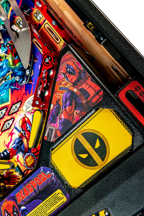 Pinball machine with Deadpool-themed artwork and accessories