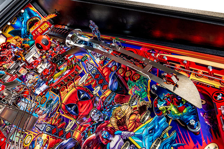 Close-up of a colorful pinball machine with various characters and elements.