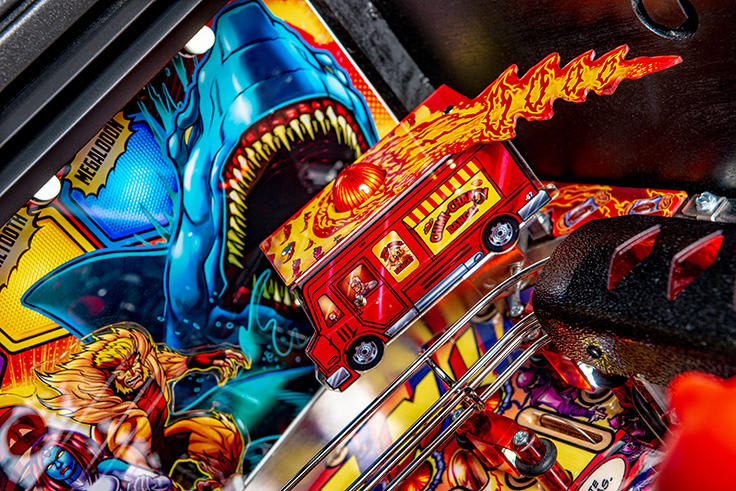 Close-up of a pinball machine with vibrant artwork and mechanical components.