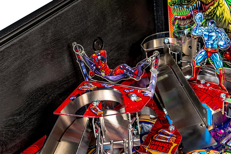 Close-up of a pinball machine with colorful figures and a black background