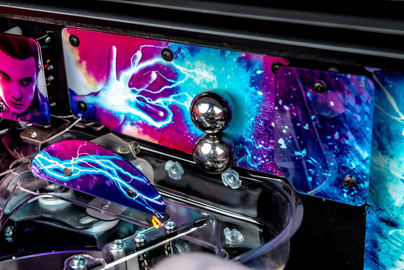 Close-up of a pinball machine with colorful artwork and metallic components.