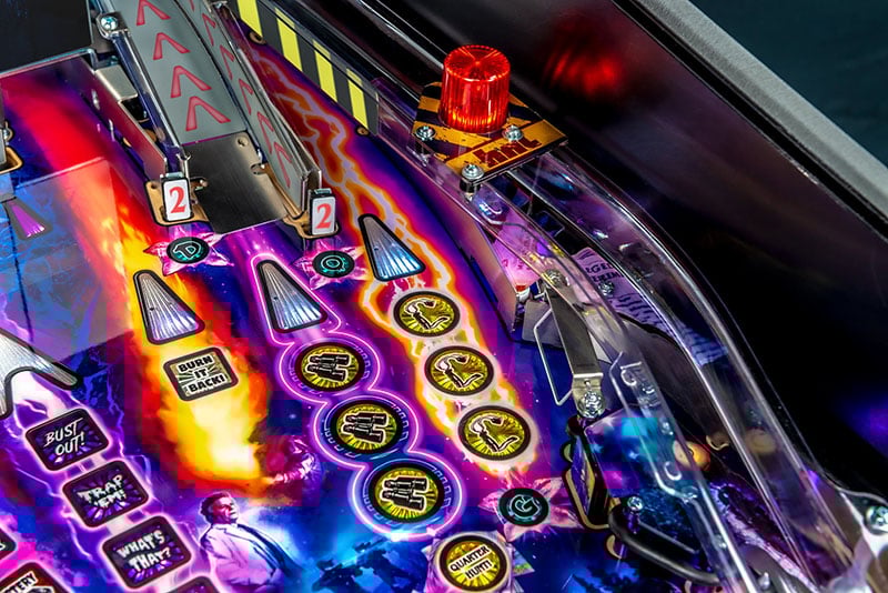 Close-up of a colorful pinball machine with glowing buttons and lights.