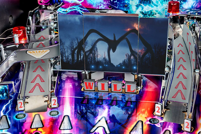 Close-up of a pinball machine with a dark scene and 'WILL' text.