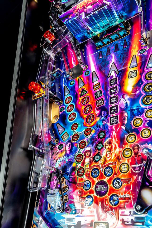 Colorful pinball machine with various buttons and lights on a dark background