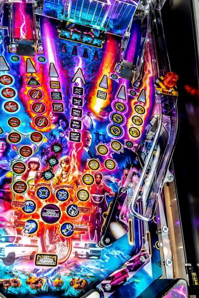 Close-up of a colorful pinball machine with vibrant lights and details.