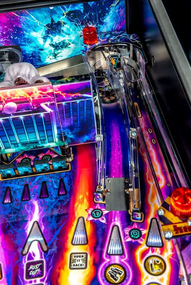 Close-up of a colorful pinball machine with vibrant graphics and bright lights.