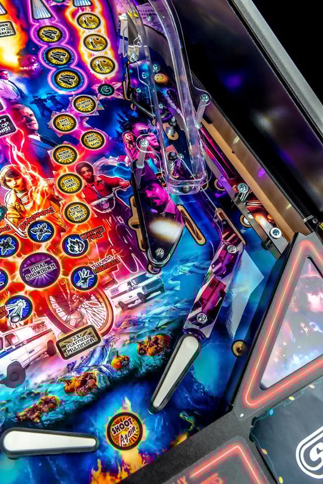 Close-up of a colorful pinball machine with vibrant graphics and bright lights.