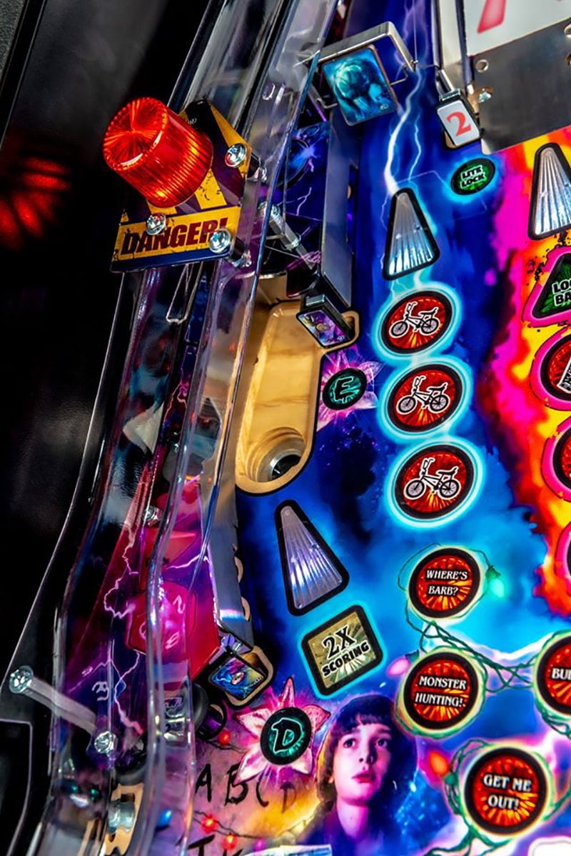 Close-up of a colorful pinball machine with various buttons and lights.