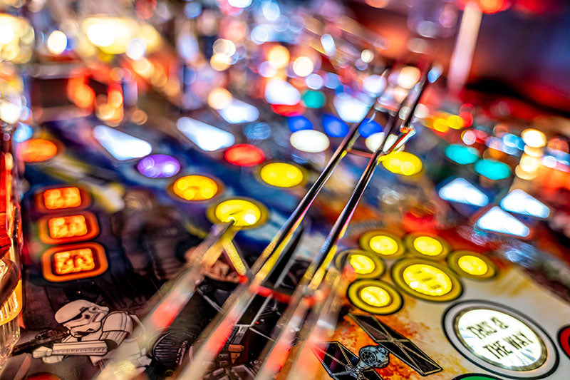 Close-up of a pinball machine with colorful lights and pins.