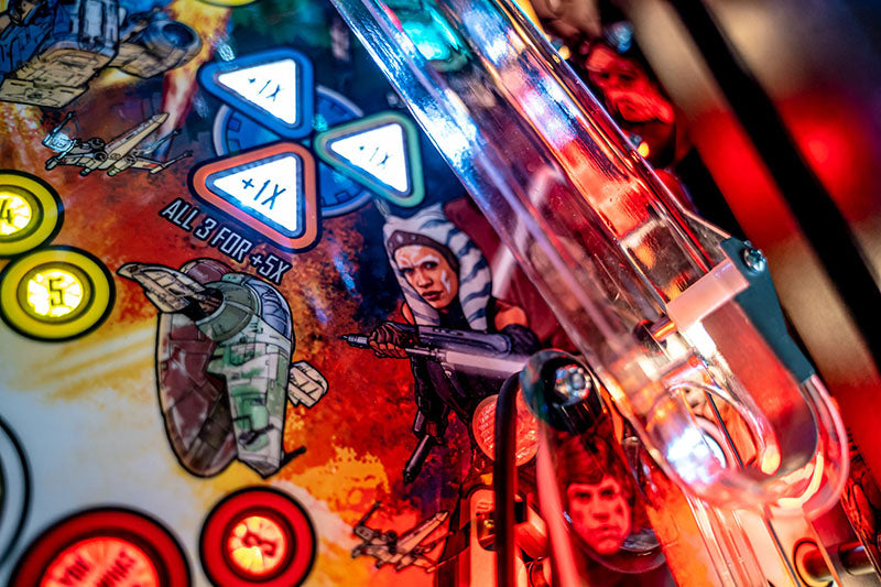 Close-up of a pinball machine with colorful lights and characters.