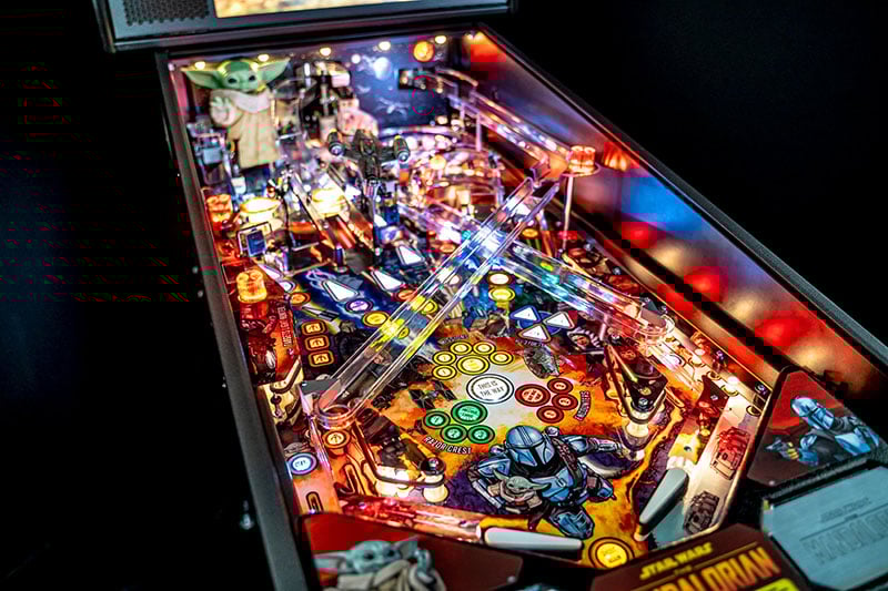 Close-up of a pinball machine with colorful lights and detailed artwork.