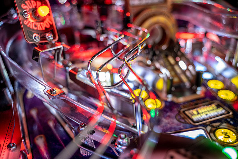 Close-up of a pinball machine with vibrant colours and mechanical details.