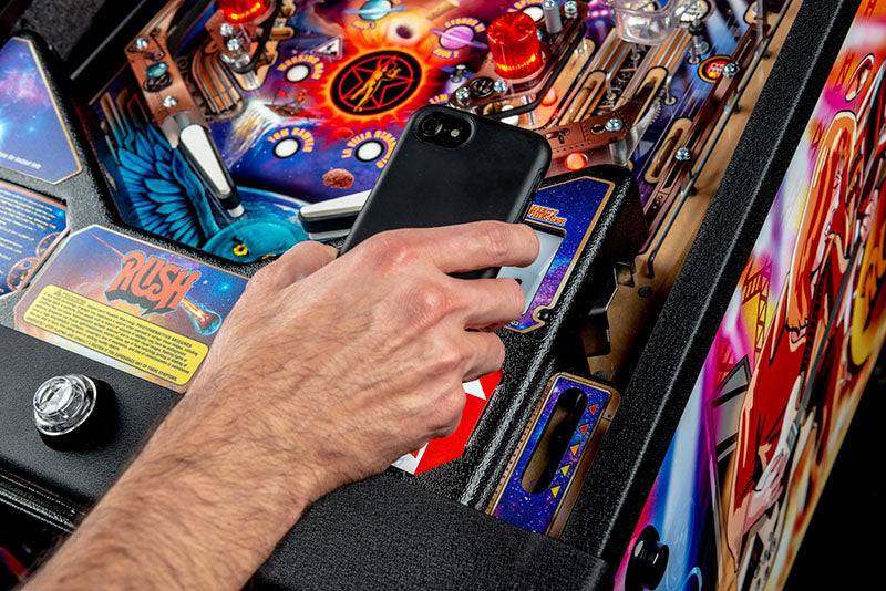Person using a smartphone to scan a QR code on a colourful pinball machine.