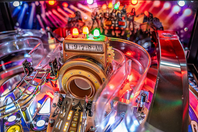 Close-up of a pinball machine with colourful lights and mechanical components.