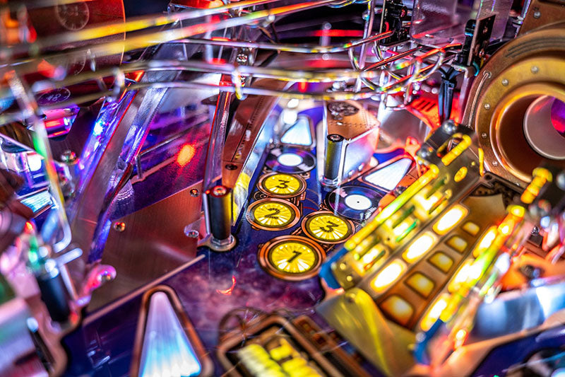 Close-up of a colourful pinball machine with bright lights and mechanical components.