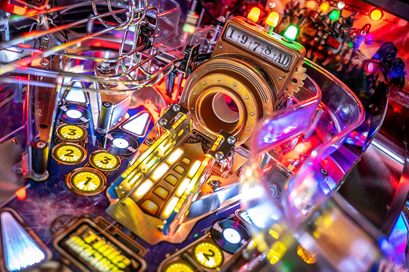 Close-up of a pinball machine with colourful lights and mechanical components.