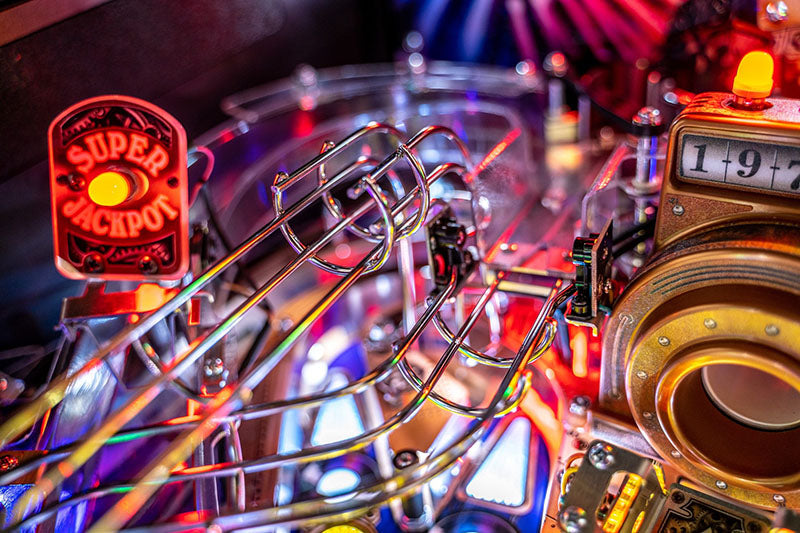 Close-up of a pinball machine with colourful lights and components.