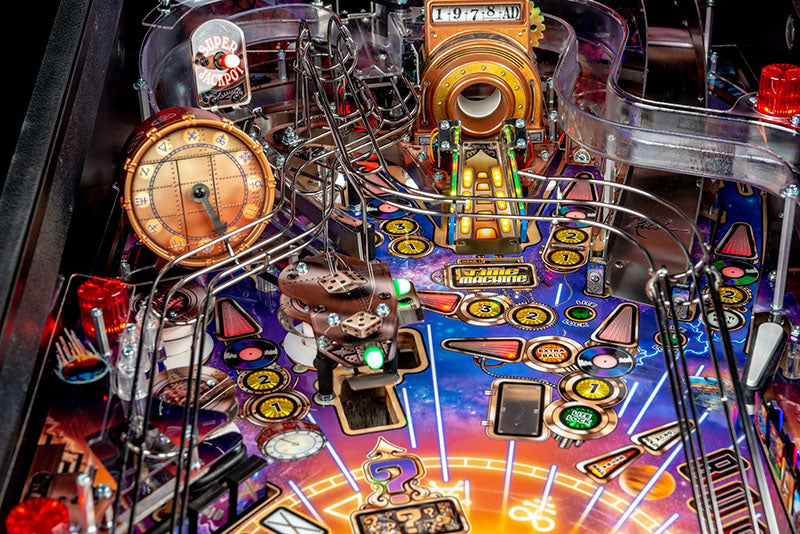 Close-up of a colourful pinball machine with various components and lights.