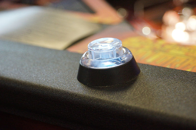 Close-up of a clear button with black base on a textured surface