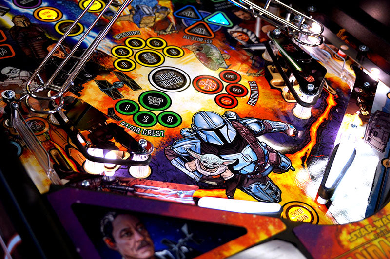 Close-up of mandalorian pinball machine with colorful design and characters.